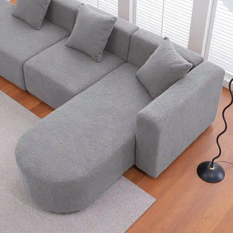 Moderno divano in bouclé a L con seduta curva (con lato lungo a destra)